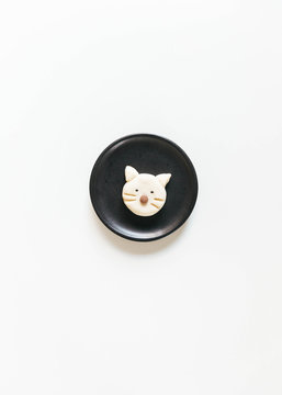 Homemade cat shaped cookie on black ceramic plate