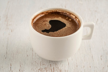 A cup of Turkish coffee on a wooden table