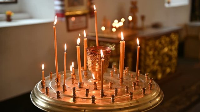 burning candles on a candlestick at the empty orthodox church