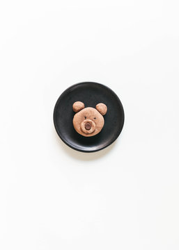 Homemade bear shaped cookie on black ceramic plate