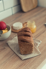 Bread on napkin on the kitchen table, cheese and fruit