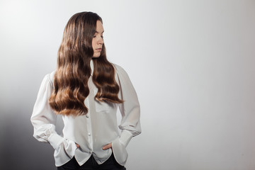 Closeup of female hands of hairdresser or coiffeur makes hairstyle. Hair