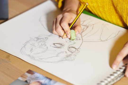 Woman erasing graphic portrait with pencil