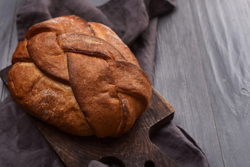 Bread on gray linen napkin on cutting board on the table