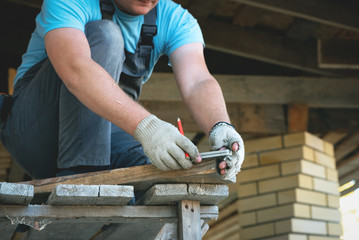 Worker is building a roof of house.