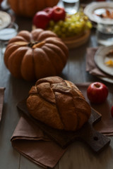 Naklejka na ściany i meble Grain bread, red apples and pumpkin on a table