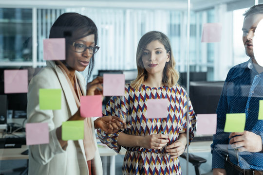 Businesspeople Looking at Glass Board