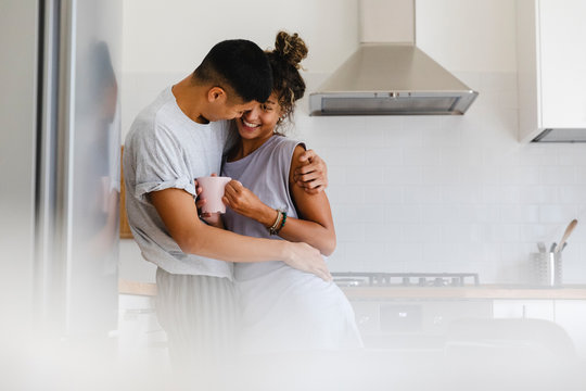 Two lovers hug each other in the kitchen