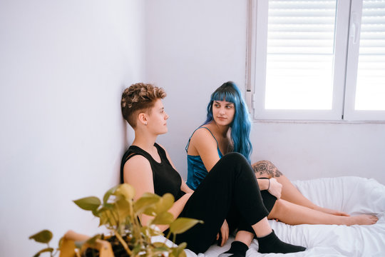 Lesbian couple comfortable in their bright white room