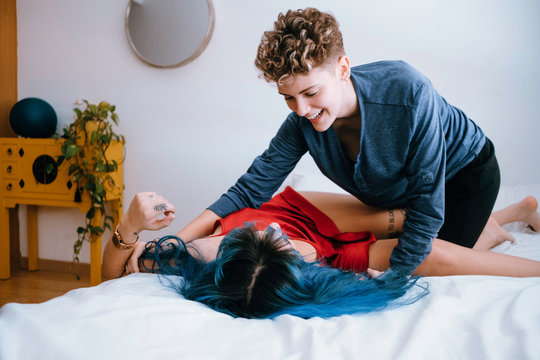 lesbian couple tickling and laughing in their bed