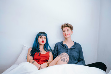 a couple of lesbians in bed leave lipstick marks on their faces