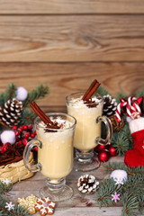 Two glasses with eggnog on the festive table with Christmas decor. Close-up.