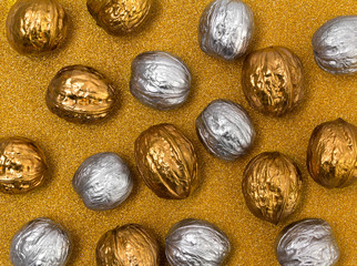 Painted golden and silver walnuts on glittering background