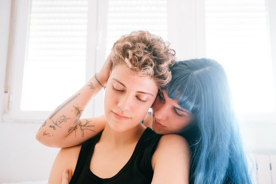 Lesbian couple comfortable in their bright white room
