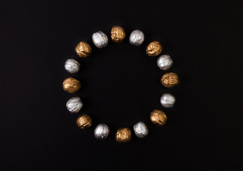 Painted golden and silver walnuts on black background