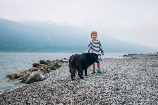 Girl with dog at a lake (Lago di Garda, Italy)