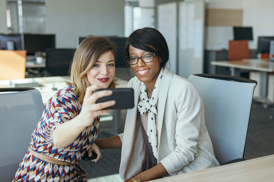 Young Businesswomen Working Together and Using Cell Phone