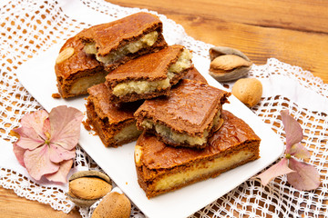 Fresh baked Dutch filled spicy cookies with almonds in autumn colors on dark wooden background