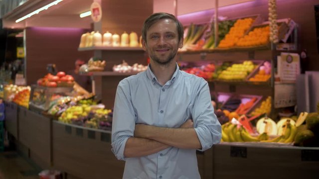 Portrait Of Man A Grocery Store Clerk Or Owner In Front Of A Vegetable Counter