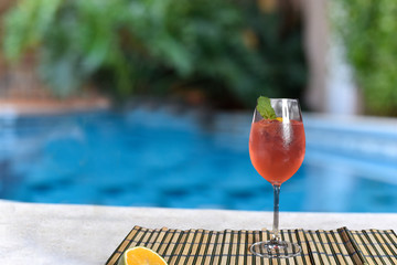 refreshing red berry drinck by the pool with sunny day