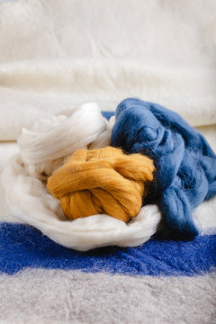Skeins of wool resting on a woolen fabric