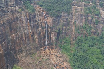 natural waterfall surrounded by cliffs full of greenery