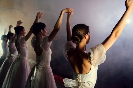 Ballerinas in dresses on scene in fog