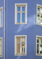 Fototapeta na wymiar White windows in blue wall.