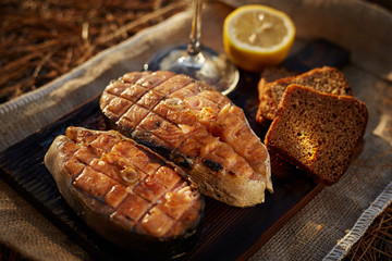 Cooked salmon steaks and ingredients on a old wooden board