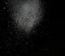 White snow falls on a black sky background. Photo of snow on a dark background