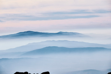 Layered mountain landscape with clouds and fog