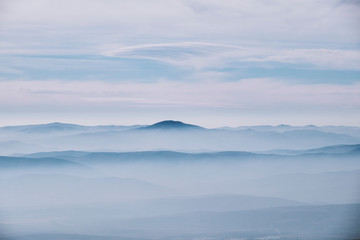 Layered mountain landscape with clouds and fog