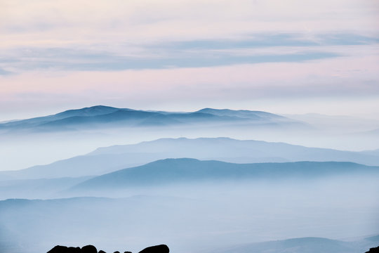 Layered mountain landscape with clouds and fog