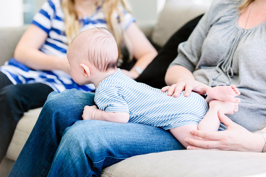 3 month old baby lying on his mother's lap