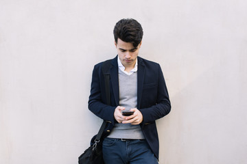 Young businessman using his cell phone on the street