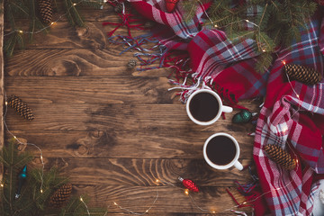 Christmas coffee cups with Sparkles, Fir Tree Branches, toys, plaid on Wooden Background. Winter Time Top View