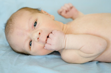 Lying on the bed sheet baby at home