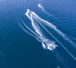 Three boats on the blue sea with trails