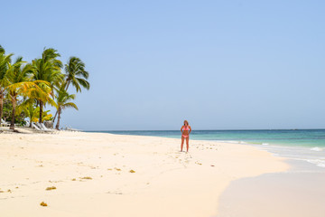 Fototapeta na wymiar Woman standing on beach in the caribbean sea, white beach and blue sky, cayo levantado