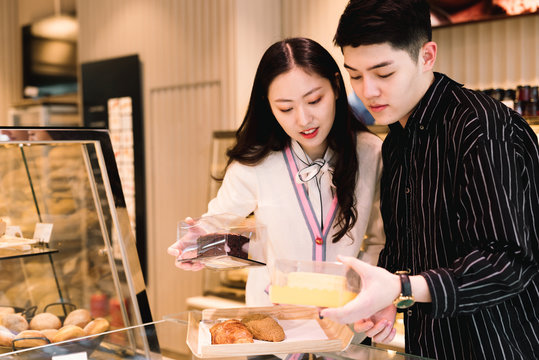 Young couple buying bakery products in store