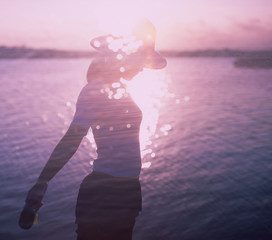 Woman's silhouette by sparkling sunset shore