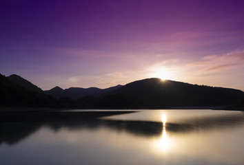 Full moon rise at dusk in the Lareo reservoir, Aralar mountain range, Euskadi