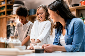 Mother near happy children in kitchen