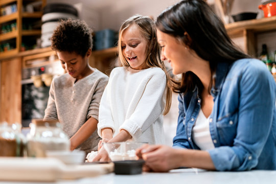 Mother near happy children in kitchen