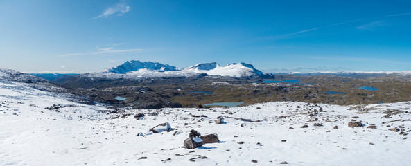 Wide panorama view from Krossbu on glacier Smorstabbreen, snow-capped mountains and blue lakes in Jotunheimen National Park, Western Norway