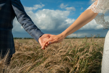 Groom and bride holding hands on ceremony wedding day