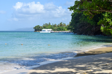 Beautiful beach with turquoise ocean, boat on the horizon