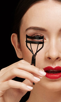 Woman using eyelashes curler