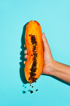 man squeezing a papaya