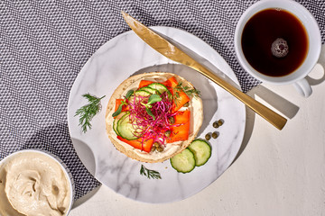 Vegan carrot smoked salmon and cashew cream cheese on bagel with coffee